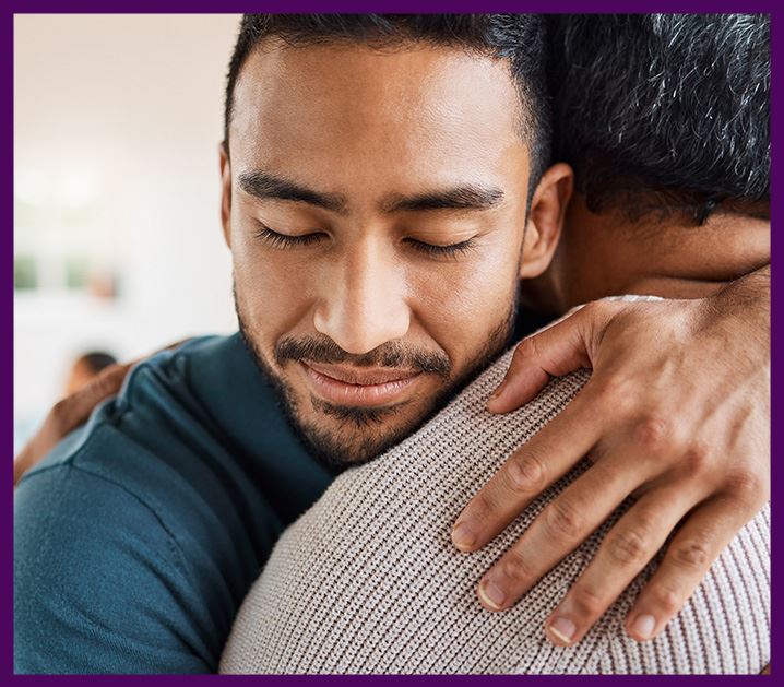 Adult son hugging parent for family support